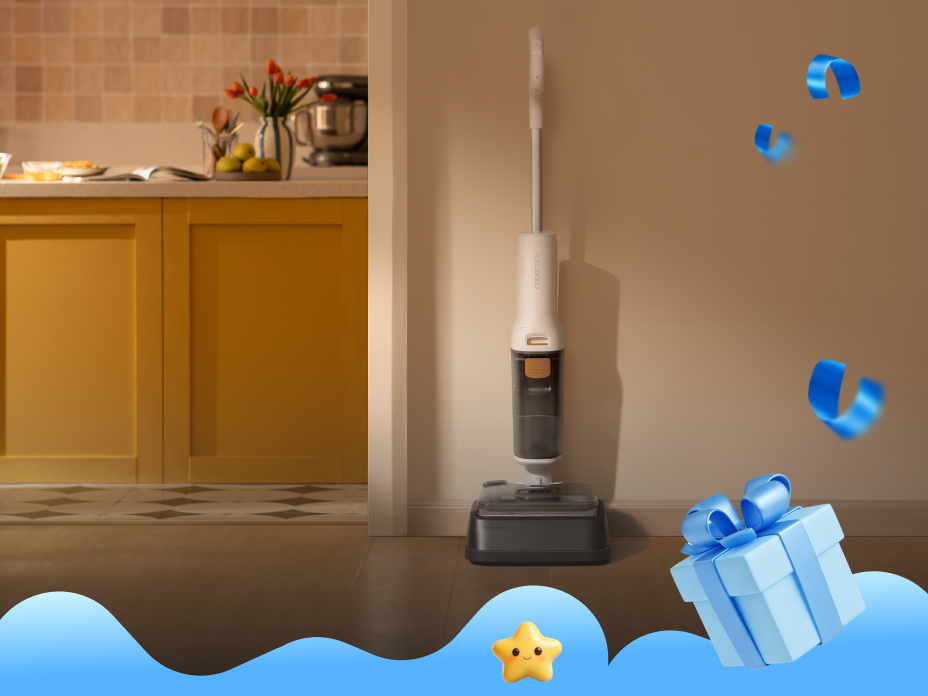A person using a white Roborock F25 GT wet/dry vacuum to clean up a cracked egg and spill on a wooden kitchen floor, with a small kitten watching nearby