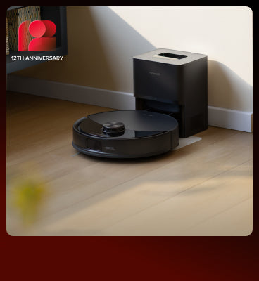 Black Roborock Q10 S5+ robot vacuum docked in a black base station on a wooden floor