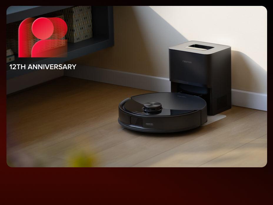 Black Roborock Q10 S5+ robot vacuum docked in a black base station on a light wooden floor