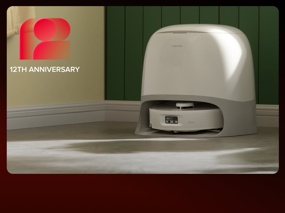 White Roborock Qrevo Curv 2 Flow robot vacuum docked in a curved white base station against a green paneled wall